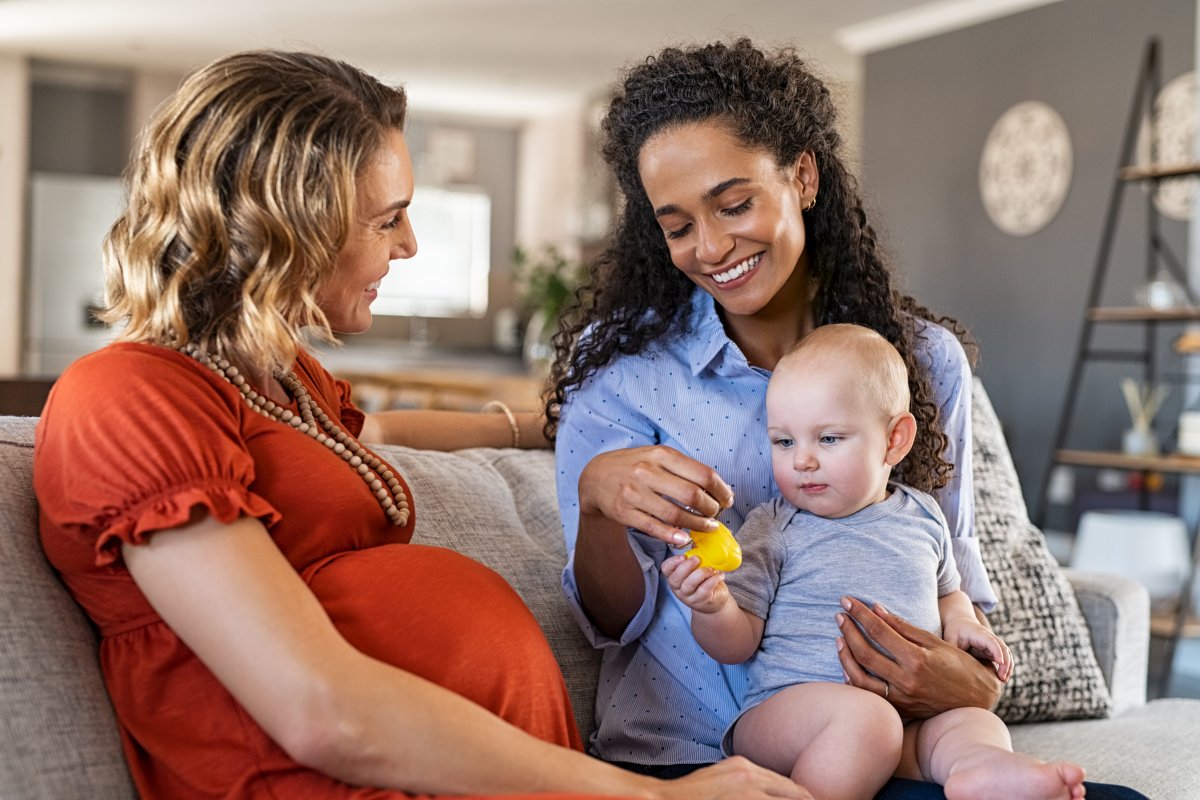 Happy women friends playing with child